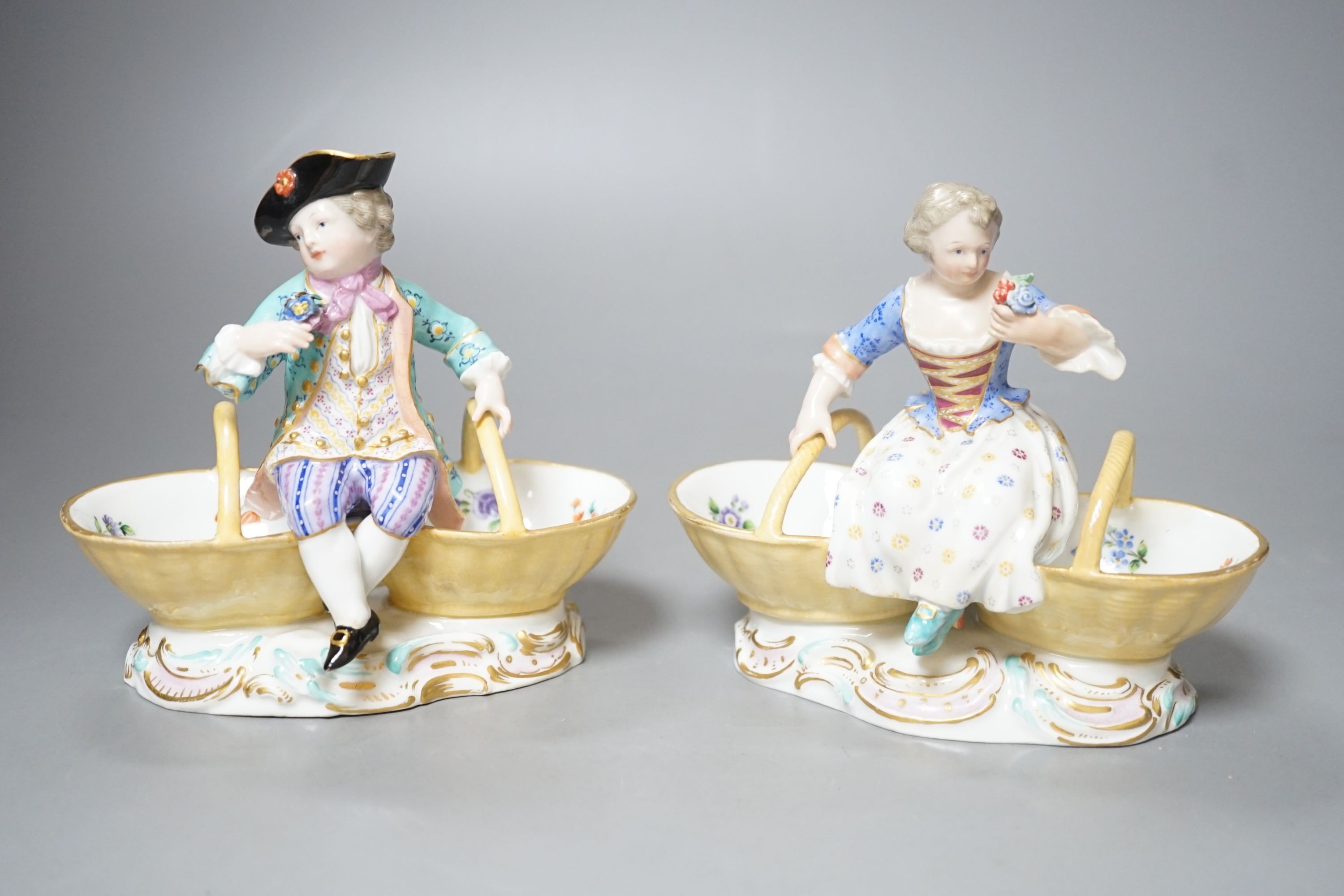 A pair of Meissen porcelain figural sweetmeat baskets, one incised number 3024, both initialled L.J.